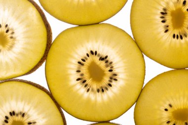 Kiwi Gold 'un arka planı. Siyah tohumlu sarı kivi dilimleri, yakın plan.