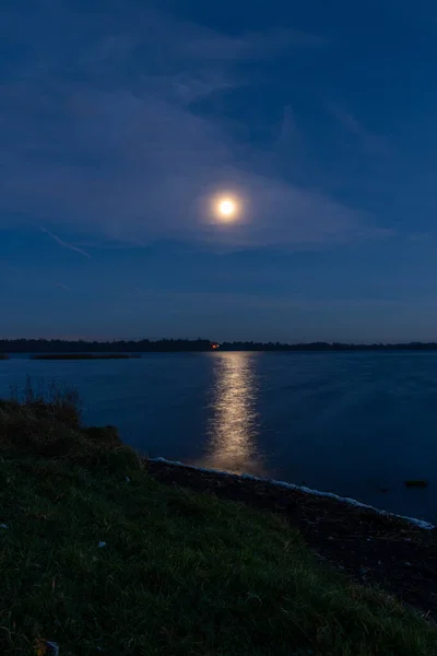 Na nocnym niebie i ścieżka księżyc nad rzeką. Gwiazdy i pasek z brzegu na horyzoncie. — Zdjęcie stockowe