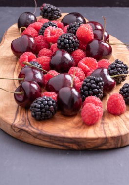 Tahta üzerinde çilek, böğürtlen ve kiraz.