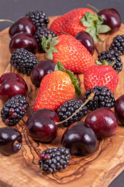 Tahta üzerinde çilek, böğürtlen ve kiraz.