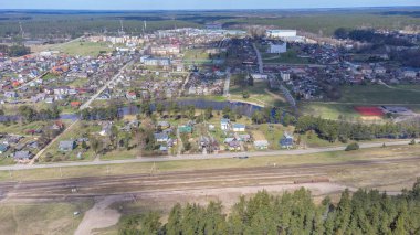 Pabrade kasabası ve çevresindeki ormanlar gökyüzü manzaralı demiryolu hatlarıyla. Litvanya, Avrupa.