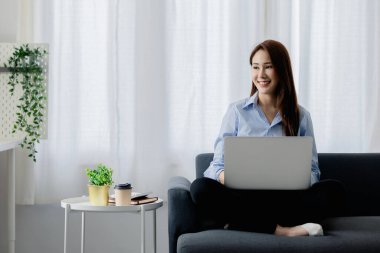 Kadın evdeki oturma odasındaki kanepede dizüstü bilgisayarda oynuyor, yoğun bir günün ardından hafta sonları dinleniyor, film izleyerek ve tabletinde müzik dinleyerek rahatlıyor. Tatil kavramı.