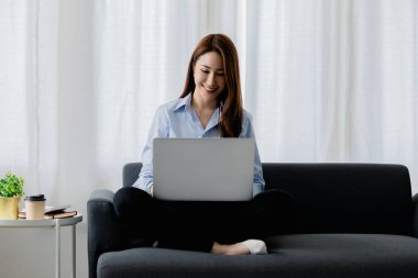 Kadın evdeki oturma odasındaki kanepede dizüstü bilgisayarda oynuyor, yoğun bir günün ardından hafta sonları dinleniyor, film izleyerek ve tabletinde müzik dinleyerek rahatlıyor. Tatil kavramı.