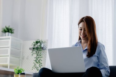 Kadın evdeki oturma odasındaki kanepede dizüstü bilgisayarda oynuyor, yoğun bir günün ardından hafta sonları dinleniyor, film izleyerek ve tabletinde müzik dinleyerek rahatlıyor. Tatil kavramı.