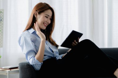 Bir kadın evdeki oturma odasındaki kanepede bir tablet çalar, yorucu bir iş gününden sonra hafta sonları dinlenir, film izleyerek ve tabletinde müzik dinleyerek dinlenir. Tatil kavramı.