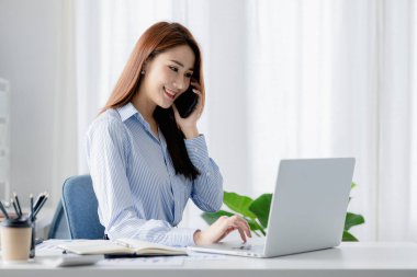 Telefonda konuşan Asyalı bir kadın, bir girişim şirketinde satış elemanı, ürün ve promosyon satmak için müşterileri arıyor. Telefon kanalları aracılığıyla ürün satma kavramı.