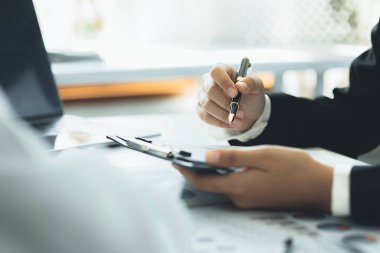 Company meeting room has businessmen and finance managers meeting together on finance topics, they are looking at information on documents and discussing together. Concept company financial management