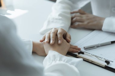 Doktor, muayene sonuçlarını bildirdikten ve hastalara tedavi yönergeleri ve reçete yazma konusunda bilgi verdikten sonra hastayı cesaretlendirmek için elini sıktı. Hastalık İnceleme Konsepti.