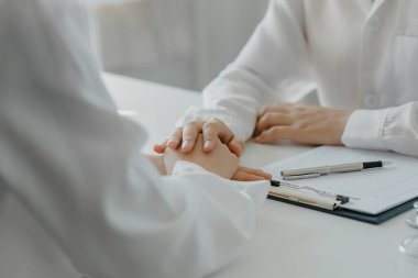 Doktor, muayene sonuçlarını bildirdikten ve hastalara tedavi yönergeleri ve reçete yazma konusunda bilgi verdikten sonra hastayı cesaretlendirmek için elini sıktı. Hastalık İnceleme Konsepti.