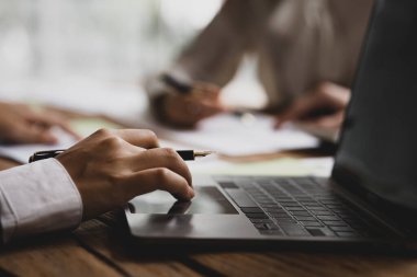 Laptop klavyesinde daktilo eden yakın plan kişi, şirket yöneticilerinin beyin fırtınası yapan ve büyümeyi planlayan bir grup yöneticinin toplantısını daktilo eden yönetici sekreter. toplantı fikri.