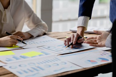 Şirket konferans odasındaki bir masada, şirkete katılan ve destekleyen belgelerle birlikte şirketin büyümesini düzeltmek ve planlamak için beyin fırtınası yapan bir grup işadamı var. İş görüşmesi fikri.