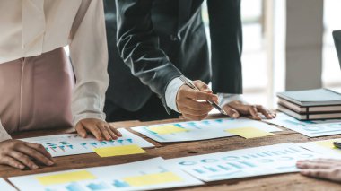 Şirket konferans odasındaki bir masada, şirkete katılan ve destekleyen belgelerle birlikte şirketin büyümesini düzeltmek ve planlamak için beyin fırtınası yapan bir grup işadamı var. İş görüşmesi fikri.