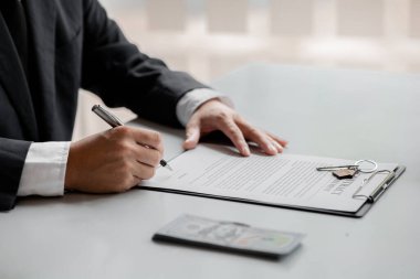 Real estate agents are drafting sales contracts for customers, drafting real estate sales contracts to be legal and fair to all parties. Real estate trading concept.