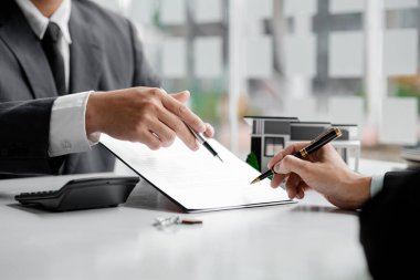 Kiralama şirketi çalışanı, müşteri kira sözleşmesini imzalamadan önce kira sözleşmesinin detaylarını ve şartlarını açıklamadan önce detayları tartışıyor. Emlak kiralama fikirleri.