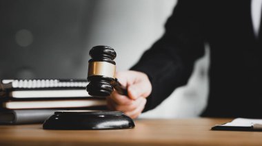 Adaletin çekicini elinde tutan kişi, avukat ya da kolluk kuvvetleri görevlisi kavramı, bir davanın kararına benzer bir çekiç tutmaktadır..