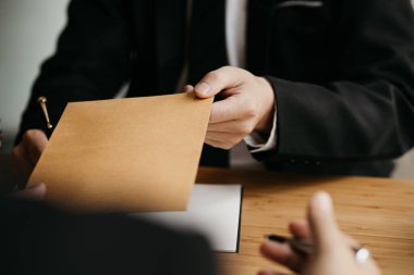 Avukatlar, iş ortaklarının zimmetine para geçirme durumlarına karşı ifade vermeye gelen müşterilerin belgelerini kabul ediyorlar. Yasal işlemler için avukat tutma kavramı.