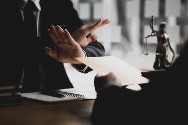 İş adamı rüşvet aldığını inkar etmek için elini kaldırdı. İçinde rüşvet olarak çok sayıda para bulunan kahverengi bir zarf. Yozlaşma kavramı..