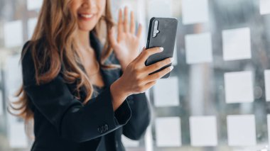 Business Woman with business partner via video call on smartphone, she is meeting with partner on planning, operations and finance of a joint startup company. Business administration concept.