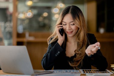 Telefonda konuşan Asyalı bir kadın, bir girişim şirketinde satış elemanı, ürün ve promosyon satmak için müşterileri arıyor. Telefon kanalları aracılığıyla ürün satma kavramı.