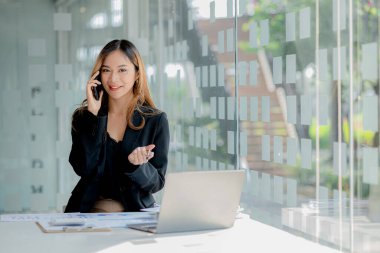 Telefonda konuşan Asyalı bir kadın, bir girişim şirketinde satış elemanı, ürün ve promosyon satmak için müşterileri arıyor. Telefon kanalları aracılığıyla ürün satma kavramı.