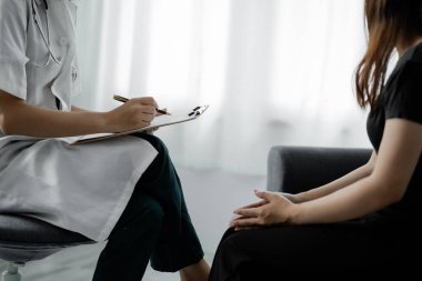 Semptomatik tedavi için doktor ve hastaların muayene ettiği, teşhis koyduğu ve reçete yazdığı bir hastanede muayene odası atmosferi. Hastalık teşhisi.