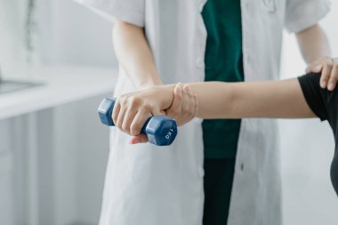 Fizyoterapist bir hasta için fizik tedavi uyguluyor, hastanın aşırı çalışma nedeniyle vücut ağrıları var ve profesyonel bir fizyoterapistle tedavi ve fizyoterapi görüyor..