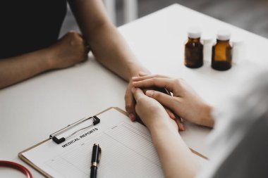 Doktor, muayene sonuçlarını bildirdikten ve hastalara tedavi yönergeleri ve reçete yazma konusunda bilgi verdikten sonra hastayı cesaretlendirmek için elini sıktı. Hastalık İnceleme Konsepti.