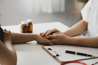 Doktor, muayene sonuçlarını bildirdikten ve hastalara tedavi yönergeleri ve reçete yazma konusunda bilgi verdikten sonra hastayı cesaretlendirmek için elini sıktı. Hastalık İnceleme Konsepti.