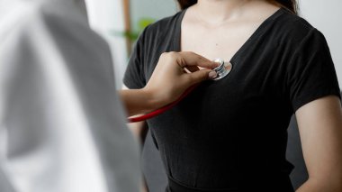 Stetoskop kullanan bir kadın doktor, hastayı muayene odasında muayene ediyor ve hastalara tedavi yönergeleri ve reçeteler hakkında bilgi veriyor. Hastalık İnceleme Konsepti.