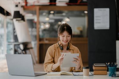 İnternette çalışmak için bilgisayar kullanan güzel bir Asyalı kadın, çevrimiçi çalışıyor. Sınıfta bir salgını önlemek için COVID-19 salgını nedeniyle çevrimiçi öğrenme kavramı.