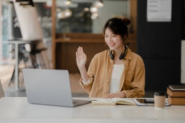 İnternette çalışmak için bilgisayar kullanan güzel bir Asyalı kadın, çevrimiçi çalışıyor. Sınıfta bir salgını önlemek için COVID-19 salgını nedeniyle çevrimiçi öğrenme kavramı.