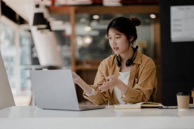 İnternette çalışmak için bilgisayar kullanan güzel bir Asyalı kadın, çevrimiçi çalışıyor. Sınıfta bir salgını önlemek için COVID-19 salgını nedeniyle çevrimiçi öğrenme kavramı.