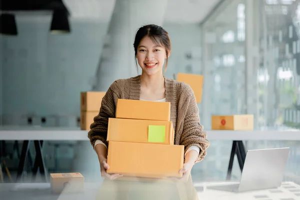 Woman owner of a startup company selling products online on an online store platform, sending goods through a courier company, Business planning. Online selling and online shopping concepts.