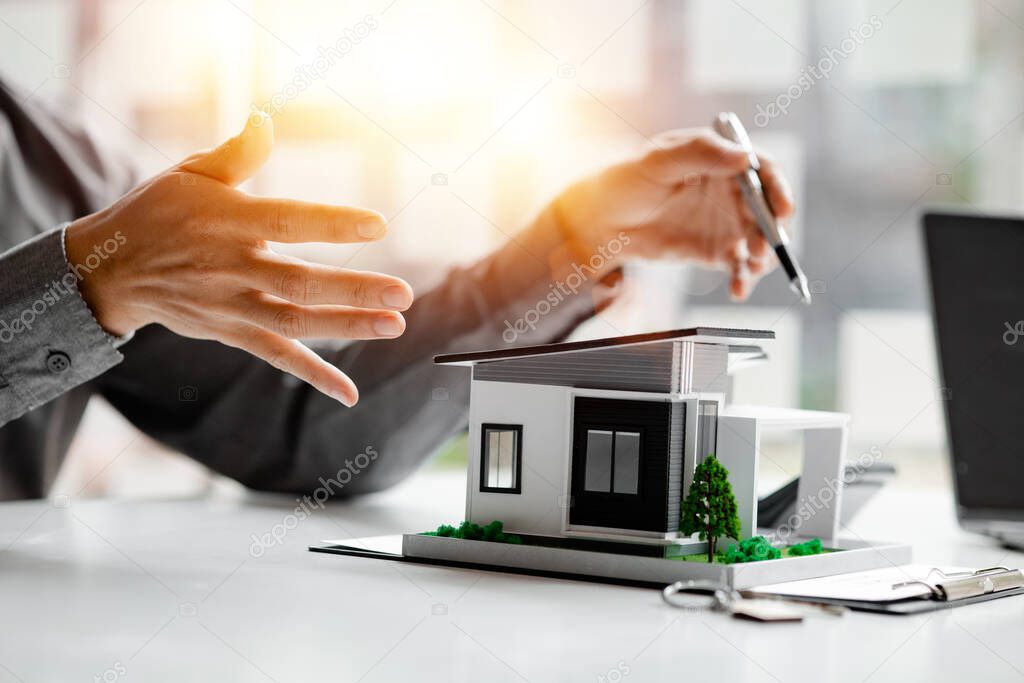 Real estate agents explain models of housing estates in projects to elaborate to clients, explaining and presenting information about homes and purchasing loans. Real estate trading concept.
