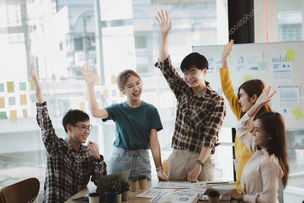 A group of young Asians are brainstorming and planning to run a growing startup business, working together to show positive energy in the organization. Management concepts of the new generation.