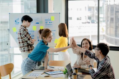 Girişimci şirket çalışanlarından oluşan gruplar konferans odasındalar, şirketin satışları ve kârlılığına baktıktan sonra sevinçlerini göstermek için el çırpıyorlar. Girişim şirketi konsepti.