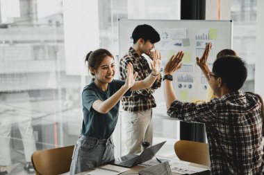 Girişimci şirket çalışanlarından oluşan gruplar konferans odasındalar, şirketin satışları ve kârlılığına baktıktan sonra sevinçlerini göstermek için el çırpıyorlar. Girişim şirketi konsepti.