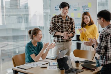 Girişimci şirket çalışanlarından oluşan gruplar konferans odasındalar, şirketin satışları ve kârlılığına baktıktan sonra sevinçlerini göstermek için el çırpıyorlar. Girişim şirketi konsepti.