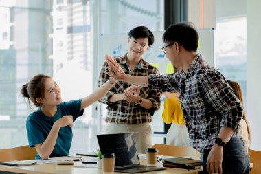 Girişimci şirket çalışanlarından oluşan gruplar konferans odasındalar, şirketin satışları ve kârlılığına baktıktan sonra sevinçlerini göstermek için el çırpıyorlar. Girişim şirketi konsepti.