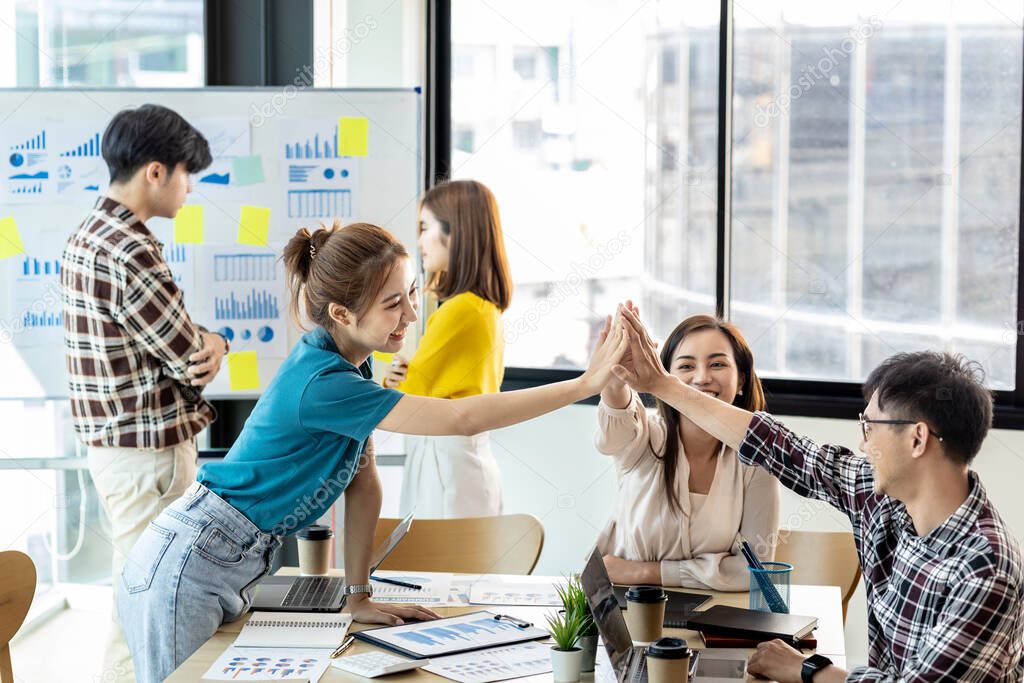 Groups of startup company employees are in the conference room, they are clapping hands to express their joy after looking at the company's sales and profitability. Startup company concept.