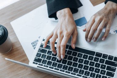 Close-up of hands resting on keyboard to view financial data, business growth in the world of cryptocurrencies and the current global economy with war and volatility. Finance and investment concepts.