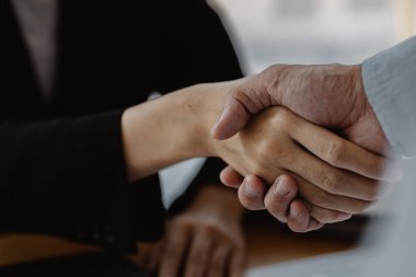 Close-up two business men holding hands, Two businessmen are agreeing on business together and shaking hands after a successful negotiation. Handshaking is a Western greeting or congratulation.