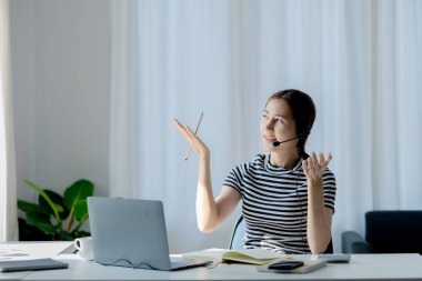 Sınıfta öğretmen ve arkadaşa iş sunan güzel Asyalı kadın, İnternet 'te okuyor. Sınıfta bir salgını önlemek için COVID-19 salgını nedeniyle çevrimiçi öğrenme kavramı.