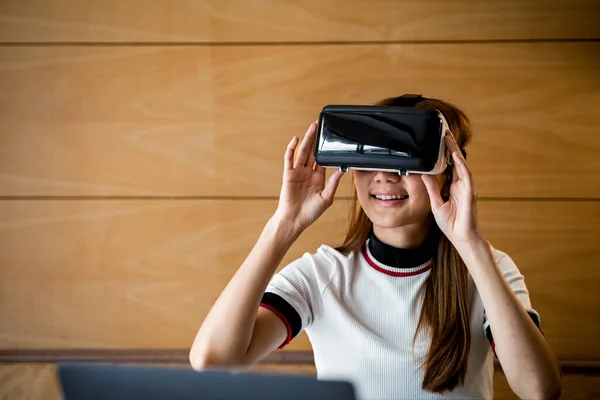 Woman wearing virtual reality glasses to use the technology of the future, using virtual reality technology to facilitate and enjoy leisure, boundless imagination, Smartphone using with VR headset.