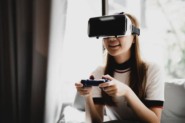 Women wearing virtual reality glasses and game joystick to play games, using virtual reality technology to facilitate and enjoy relaxation, boundless imagination, Smartphone using with VR headsets.