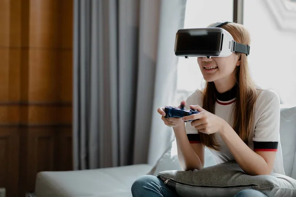 Women wearing virtual reality glasses and game joystick to play games, using virtual reality technology to facilitate and enjoy relaxation, boundless imagination, Smartphone using with VR headsets.