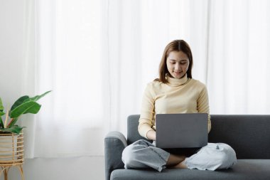 Kadın evdeki oturma odasındaki kanepede dizüstü bilgisayarda oynuyor, yoğun bir günün ardından hafta sonları dinleniyor, film izleyerek ve tabletinde müzik dinleyerek rahatlıyor. Tatil kavramı.