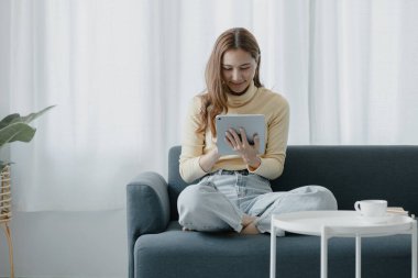 Bir kadın evdeki oturma odasındaki kanepede bir tablet çalar, yorucu bir iş gününden sonra hafta sonları dinlenir, film izleyerek ve tabletinde müzik dinleyerek dinlenir. Tatil kavramı.