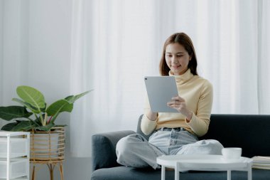 Bir kadın evdeki oturma odasındaki kanepede bir tablet çalar, yorucu bir iş gününden sonra hafta sonları dinlenir, film izleyerek ve tabletinde müzik dinleyerek dinlenir. Tatil kavramı.