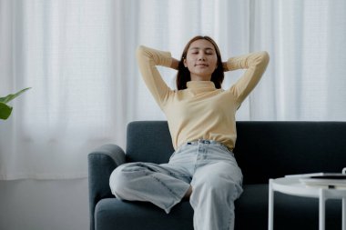 Esneme hareketleri yapan kadın. O, tatilde oturma odasındaki kanepede dinleniyor. Yoga pozları verip yorucu bir iş gününden sonra rahatlıyor. Sıkı çalışmaya ara verme fikri..